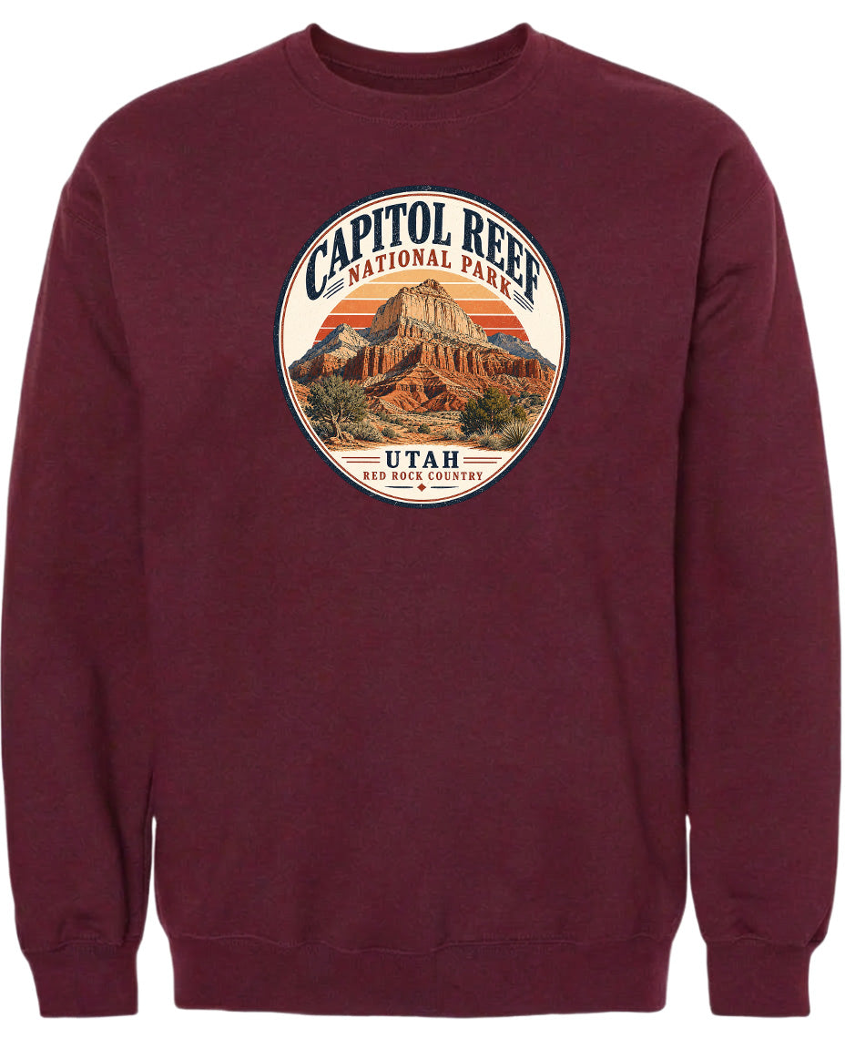 A burgundy-colored sweatshirt with a circular graphic design featuring the Capitol Reef National Park in Utah.