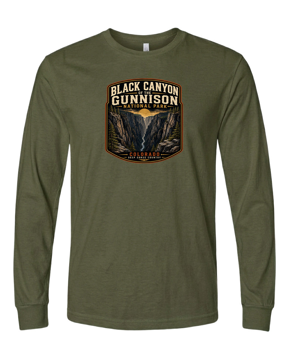 A long-sleeved olive green t-shirt with a graphic design depicting a mountainous landscape, specifically the Black Canyon of the Gunnison National Park in Colorado.