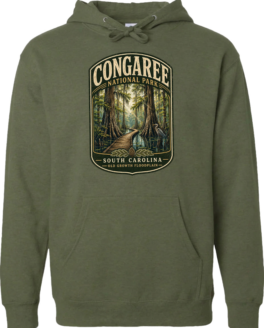 A green hoodie with a graphic design depicting a forest path leading through Congaree National Park in South Carolina.