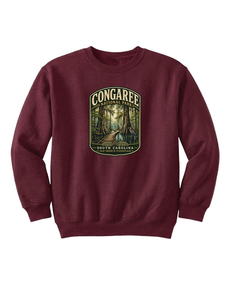 A burgundy sweatshirt with a graphic design depicting a forest scene, featuring the text "CONGAREE NATIONAL PARK SOUTH CAROLINA" prominently displayed.