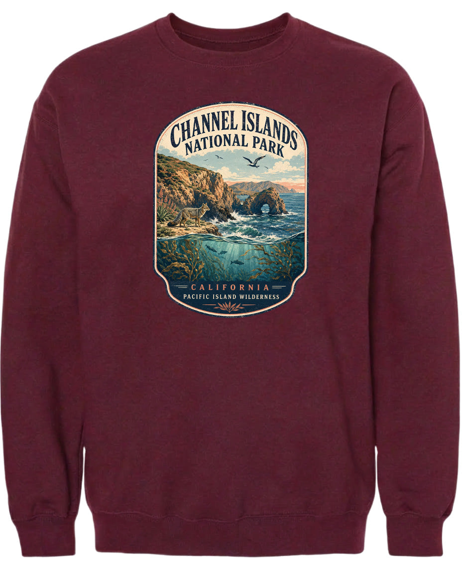 A maroon sweatshirt with a graphic design depicting a scenic coastal landscape, including cliffs, water, and birds.