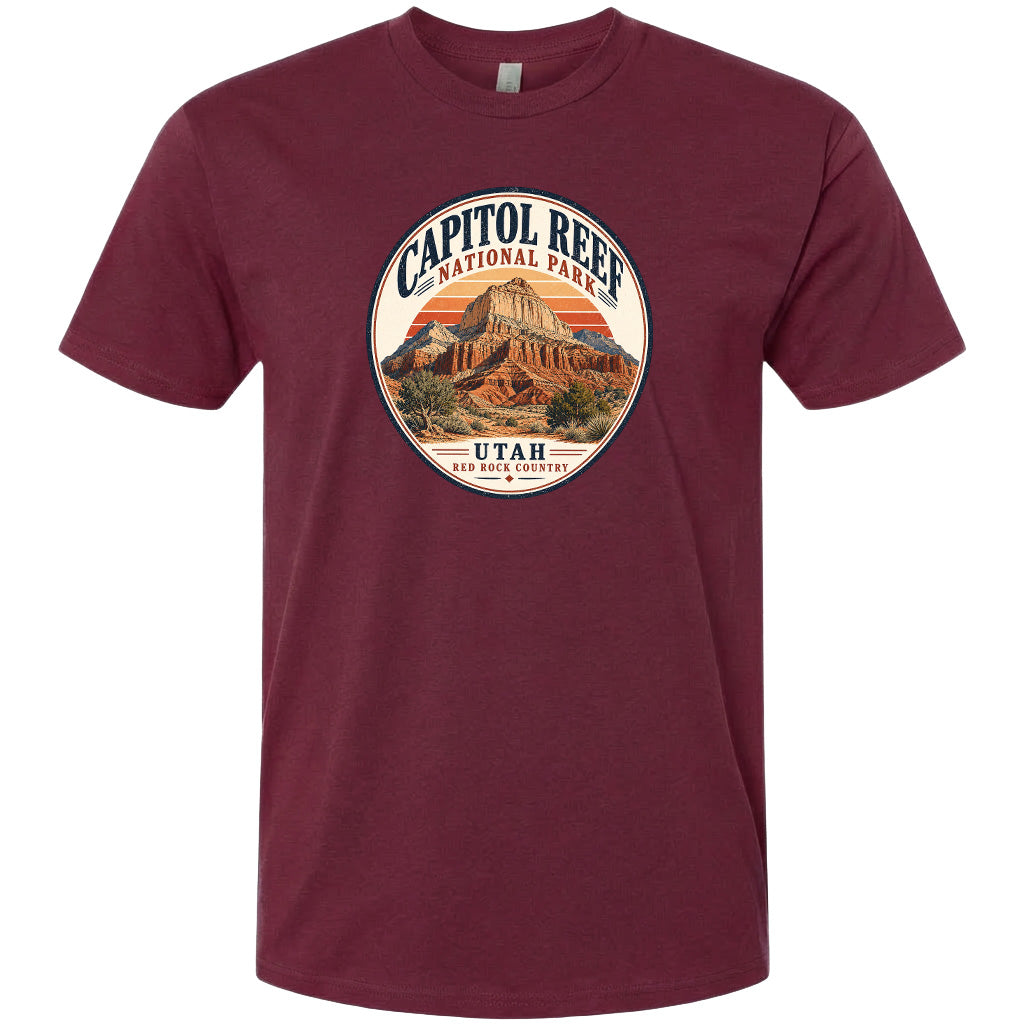 A t-shirt with a circular design featuring the Capitol Reef National Park in Utah, with a mountain and sunset in the background.