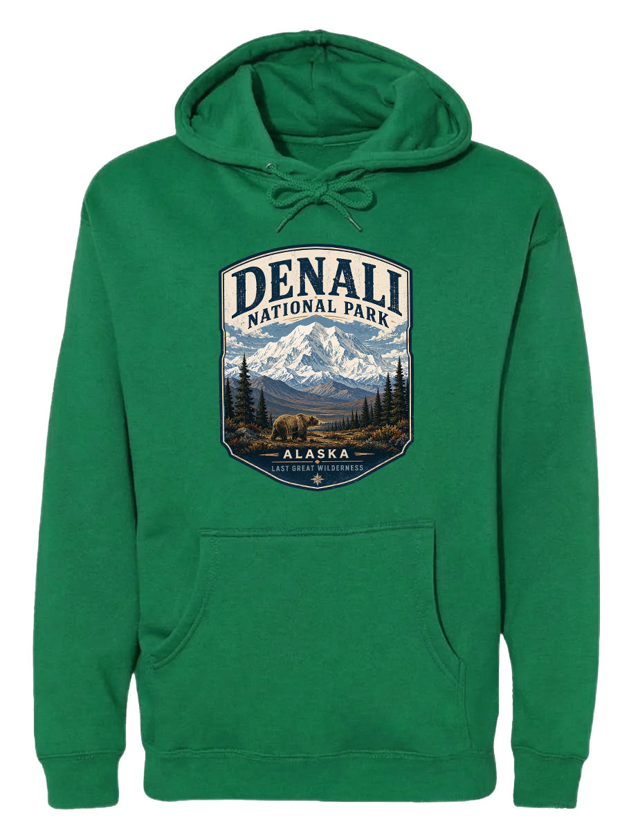 A green hoodie with a graphic design depicting Denali National Park and Alaska, featuring a mountain landscape with a bear.