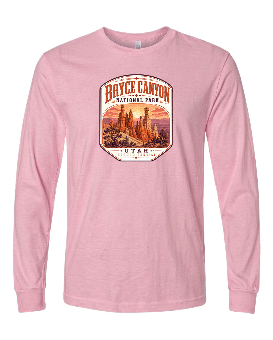 A pink long-sleeved t-shirt with a graphic design depicting Bryce Canyon National Park and Utah.
