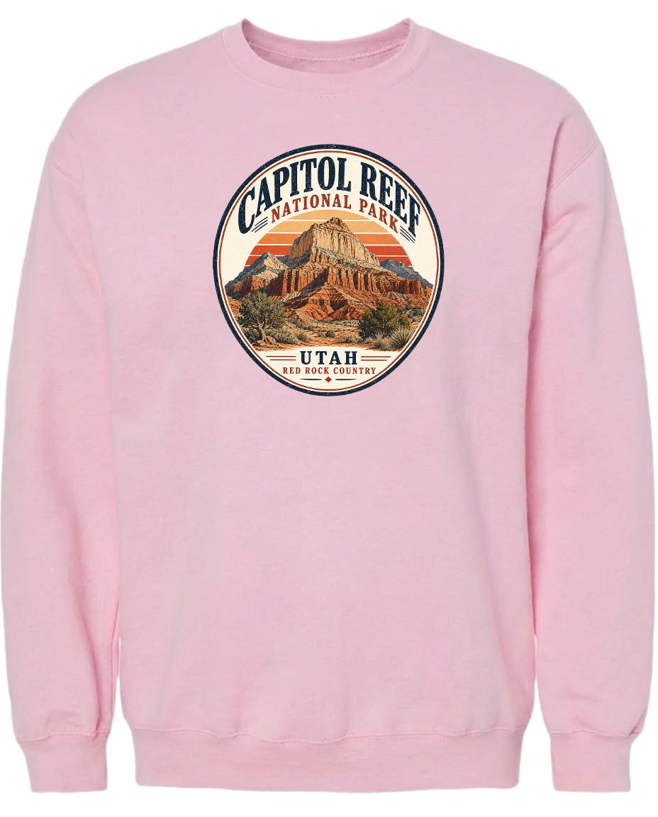 A pink sweatshirt with a circular graphic design featuring the Capitol Reef National Park in Utah.