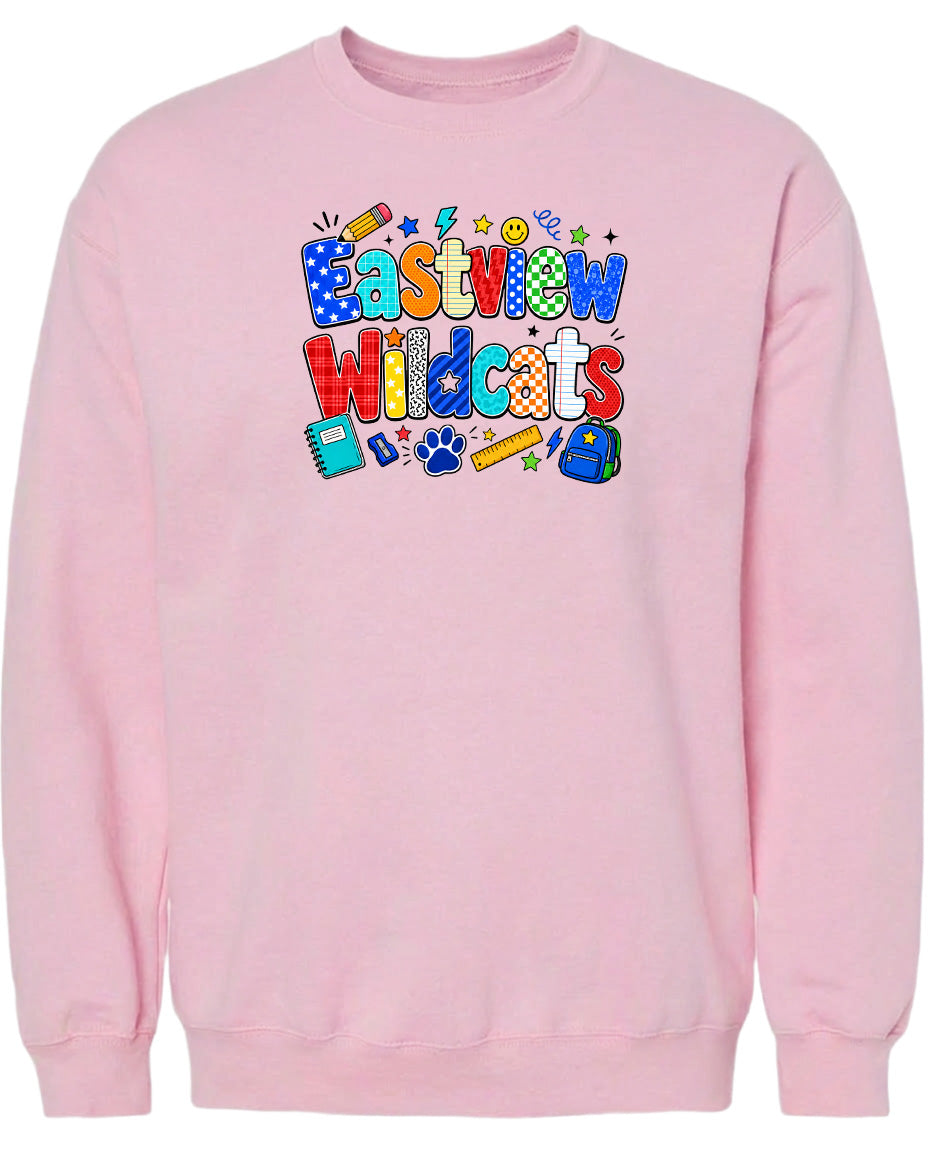 A pink sweatshirt with a colorful graphic design featuring the text "Eastview Wildcats" and various school-related icons such as a pencil, backpack, and calculator.