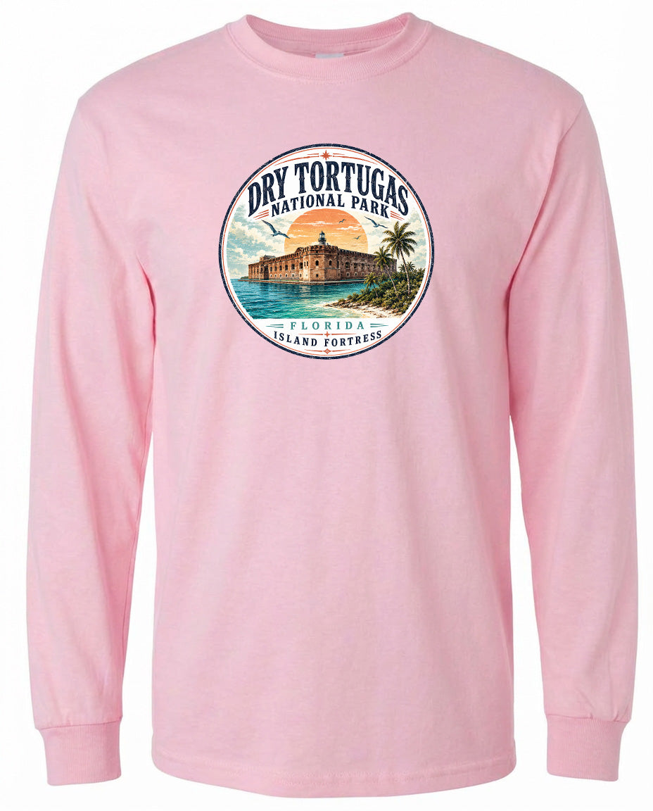 A pink long-sleeved t-shirt with a circular graphic design featuring a beach scene and a building, likely representing Dry Tortugas National Park in Florida.
