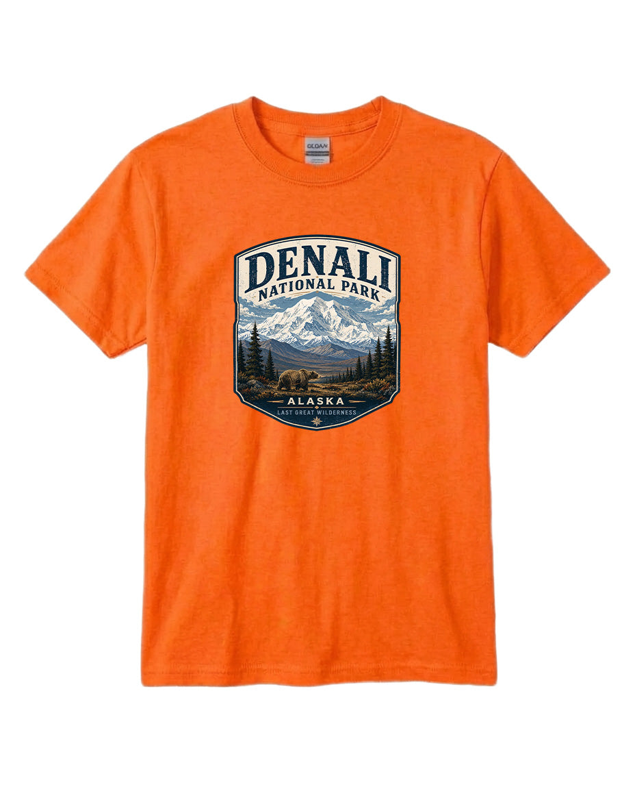 An orange t-shirt with a graphic design depicting a mountain landscape and bears, representing Denali National Park in Alaska.