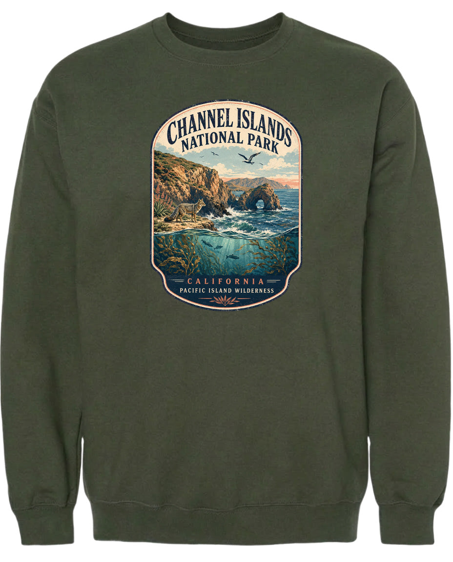 A graphic design on a dark green sweatshirt depicting a scenic landscape with cliffs, water, and a bird in flight.