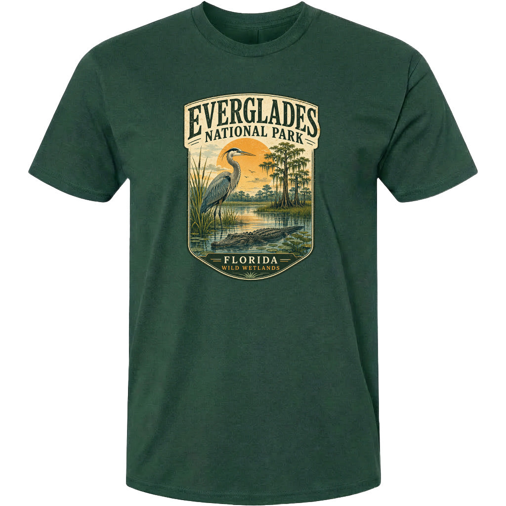 A green t-shirt with a graphic design depicting a bird, a water body, and a landscape with trees and a body of water.