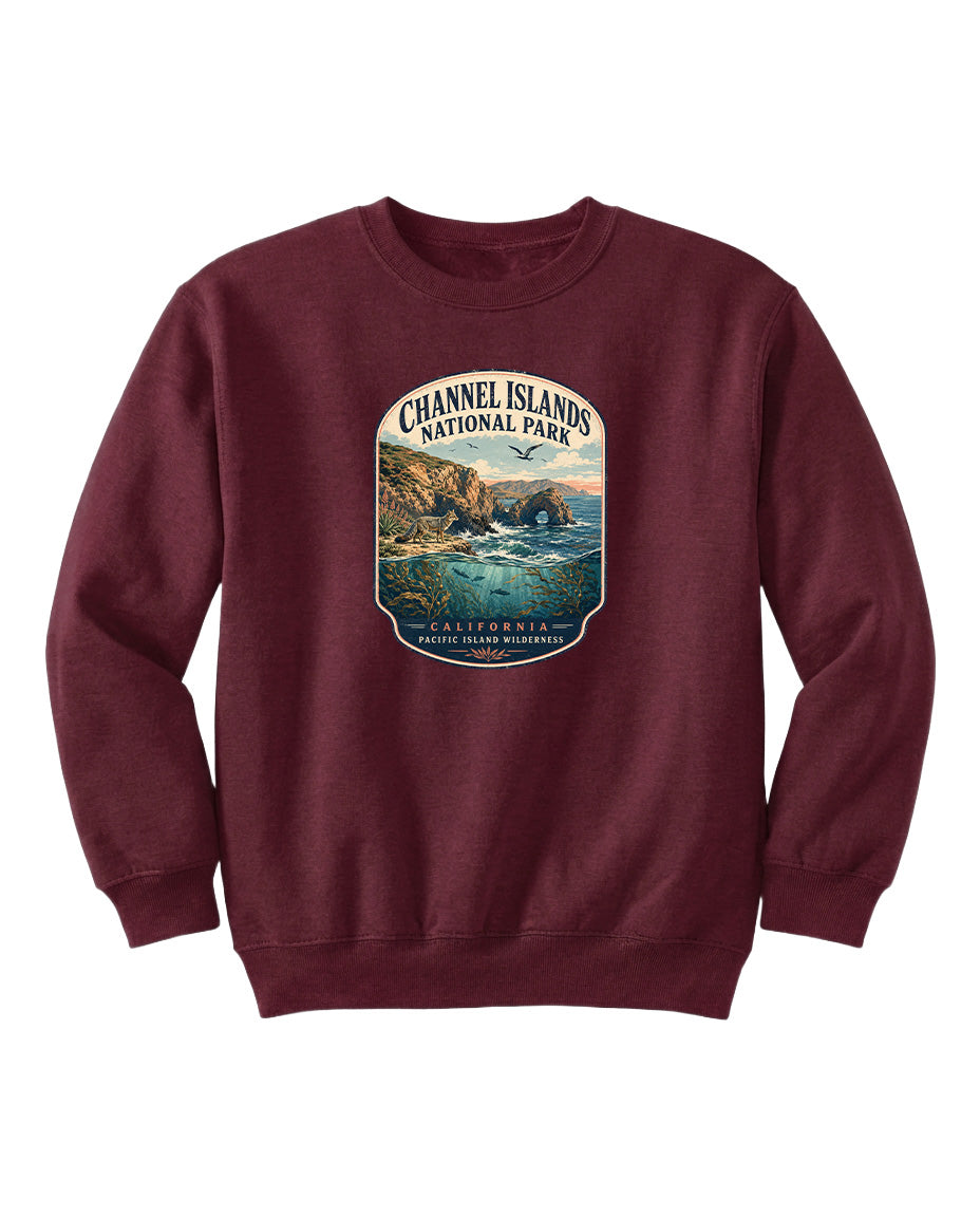 A burgundy sweatshirt with a graphic design depicting a scenic coastal landscape, including cliffs, water, and a sunset.