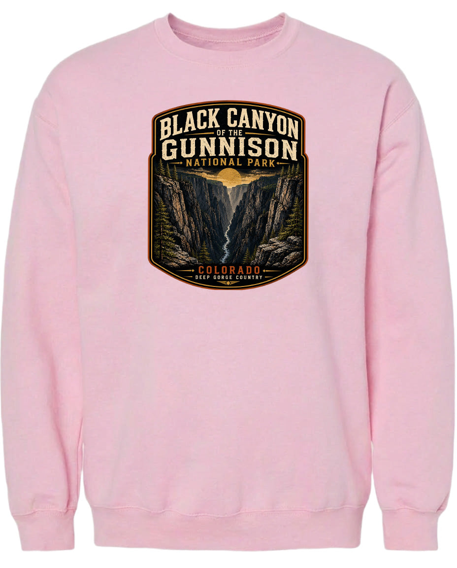 A pink sweatshirt with a graphic design depicting the Black Canyon of the Gunnison National Park in Colorado.