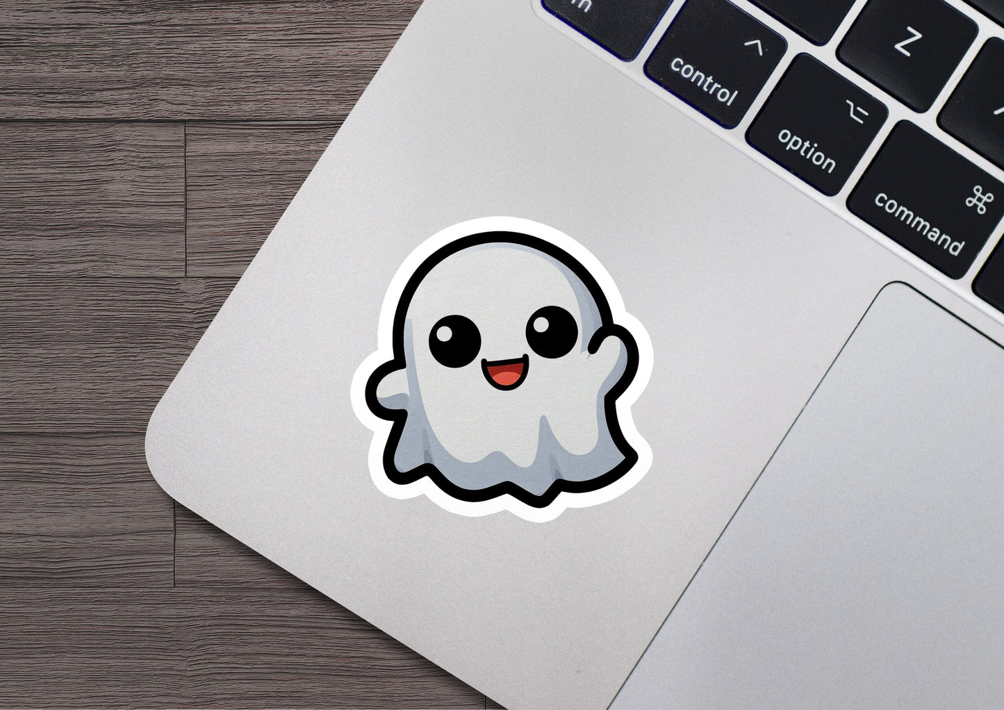 a laptop with a sticker of a ghost on it