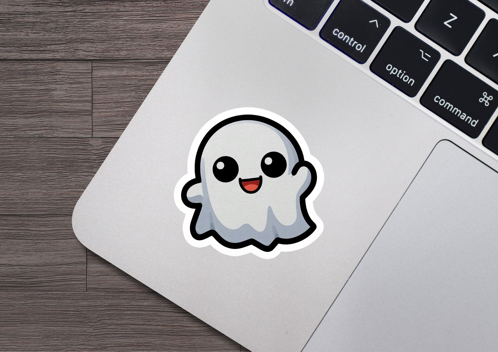 a laptop with a sticker of a ghost on it
