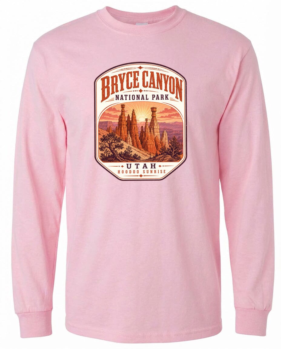 A pink long-sleeved t-shirt with a graphic design depicting the Bryce Canyon National Park in Utah, featuring the iconic hoodoos and the sunrise.