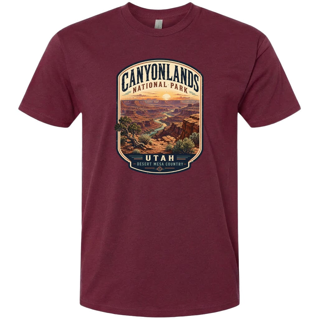 A t-shirt design featuring a scenic landscape with mountains, trees, and a winding river, with the text "CANYONLANDS NATIONAL PARK" and "UTAH" prominently displayed.