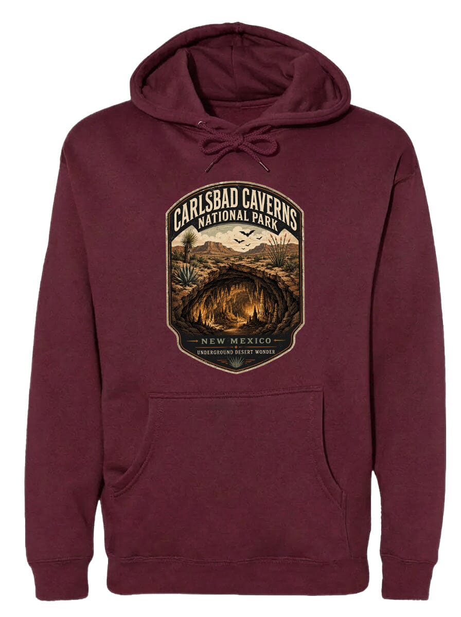 A burgundy hoodie with a graphic design depicting the Carlsbad Caverns National Park in New Mexico, featuring a cave and desert landscape.