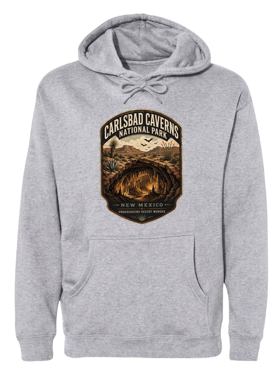 A gray hoodie with a graphic design depicting the Carlsbad Caverns National Park in New Mexico, featuring a cave, desert landscape, and birds in flight.