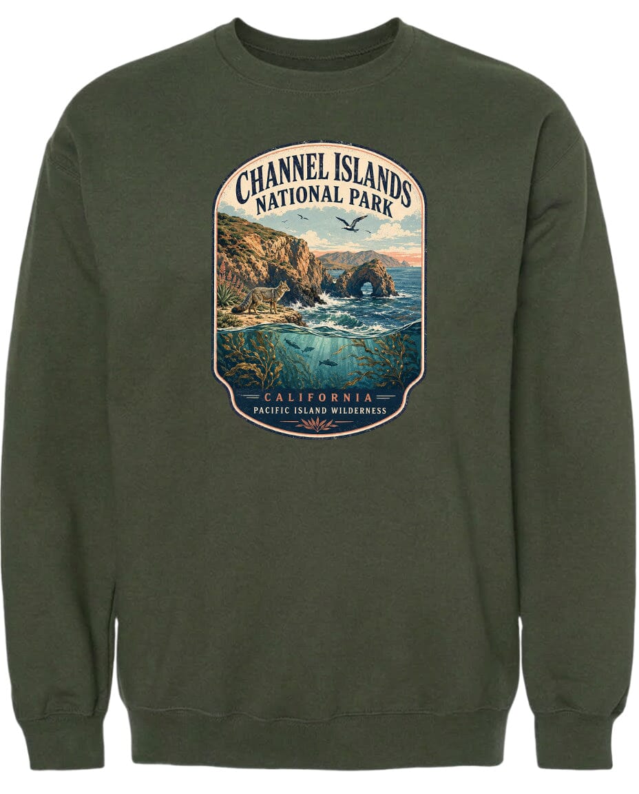 A graphic design on a dark green sweatshirt depicting a scenic landscape with cliffs, water, and a bird in flight.
