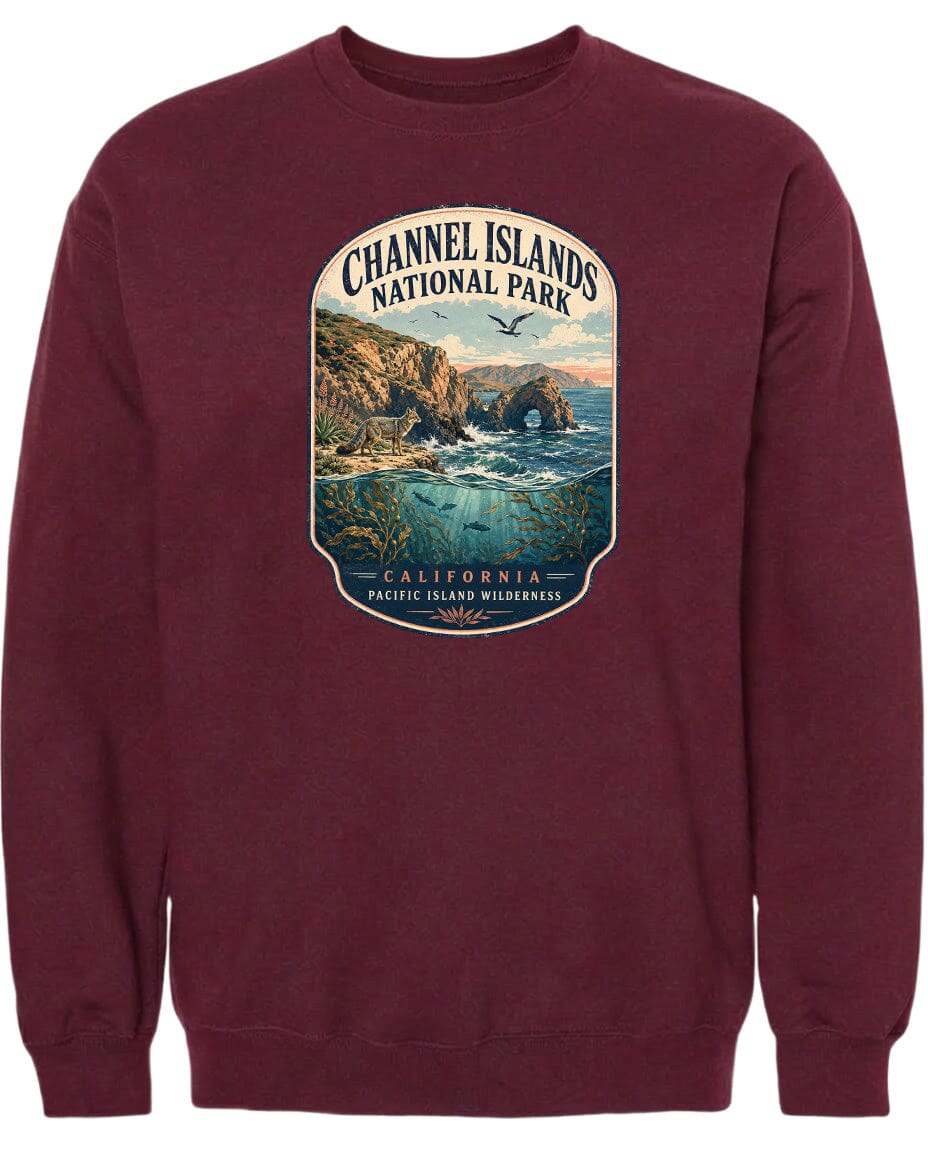 A maroon sweatshirt with a graphic design depicting a scenic coastal landscape, including cliffs, water, and birds.