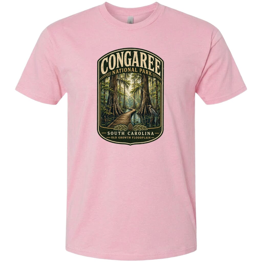 A pink t-shirt with a graphic design depicting a forest scene with a path leading through it, surrounded by trees and foliage.