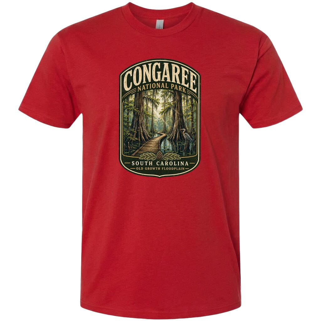 A red t-shirt with a graphic design depicting a forest scene, featuring a path leading through the trees and the text "CONGAREE NATIONAL PARK SOUTH CAROLINA OLD GROWTH FLOODPLAIN".