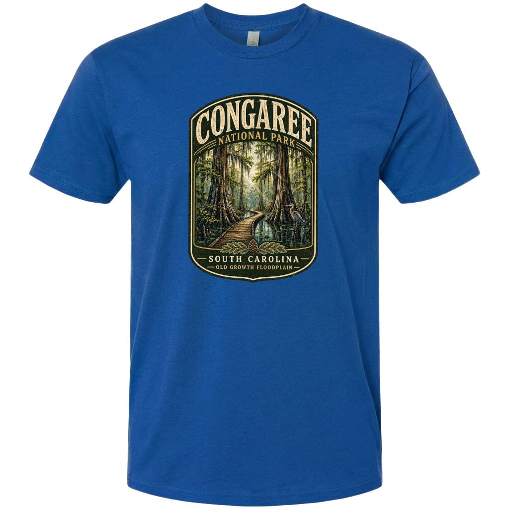 A blue t-shirt with a graphic design depicting a forest scene with a path leading through it, surrounded by trees and foliage.