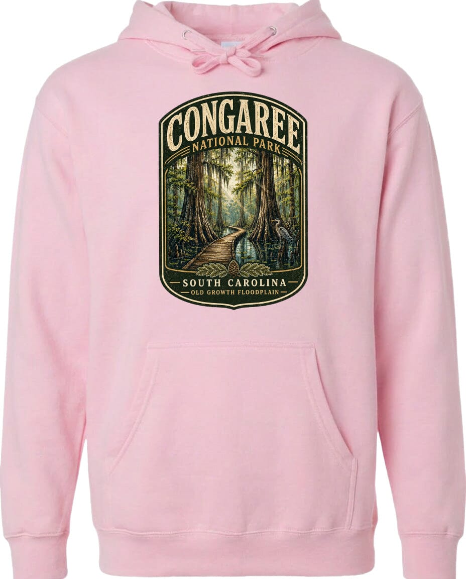 A pink hoodie with a graphic design depicting a forest scene and a path leading through it, along with the text "CONGAREE NATIONAL PARK SOUTH CAROLINA".