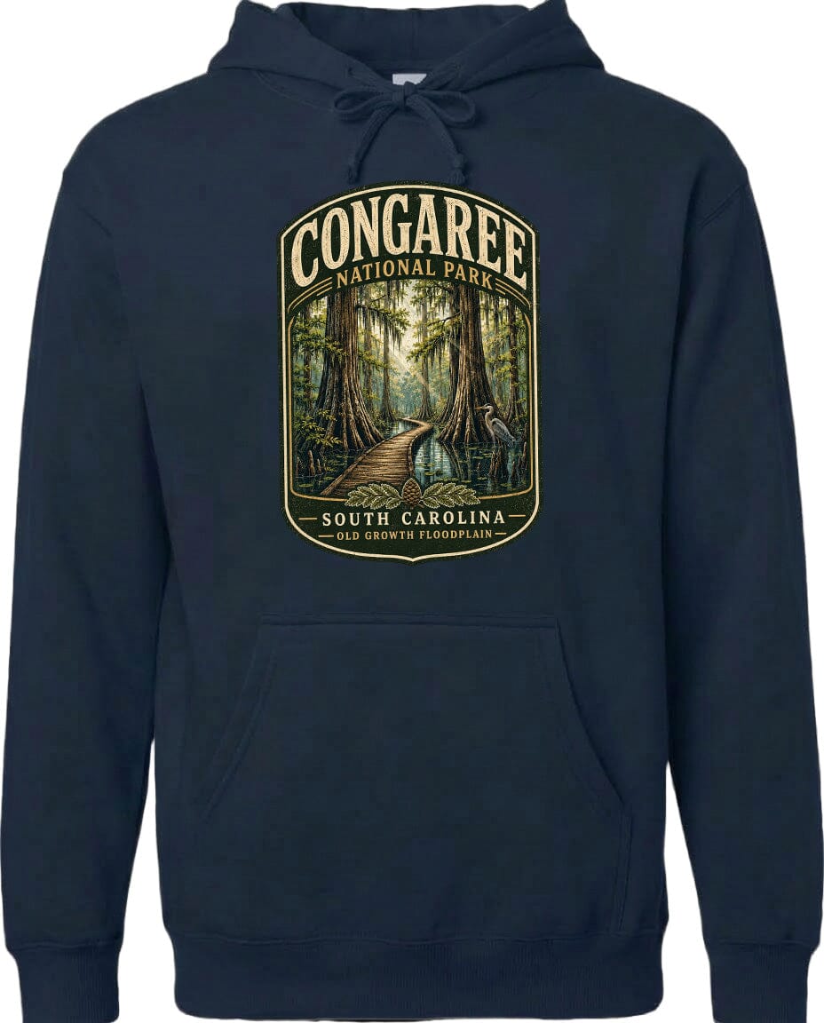 A navy blue hoodie with a graphic design depicting a forest scene, featuring a path leading through the trees and the text "CONGAREE NATIONAL PARK SOUTH CAROLINA OLD GROWTH FLOODPLAIN".