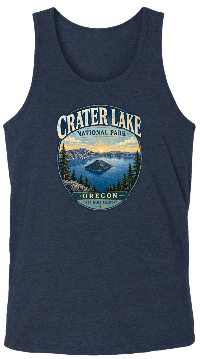 A graphic design on a dark blue tank top featuring a scenic landscape with a lake, mountains, and pine trees, along with the text "Crater Lake National Park Oregon" and "Deep Blue Caldera".