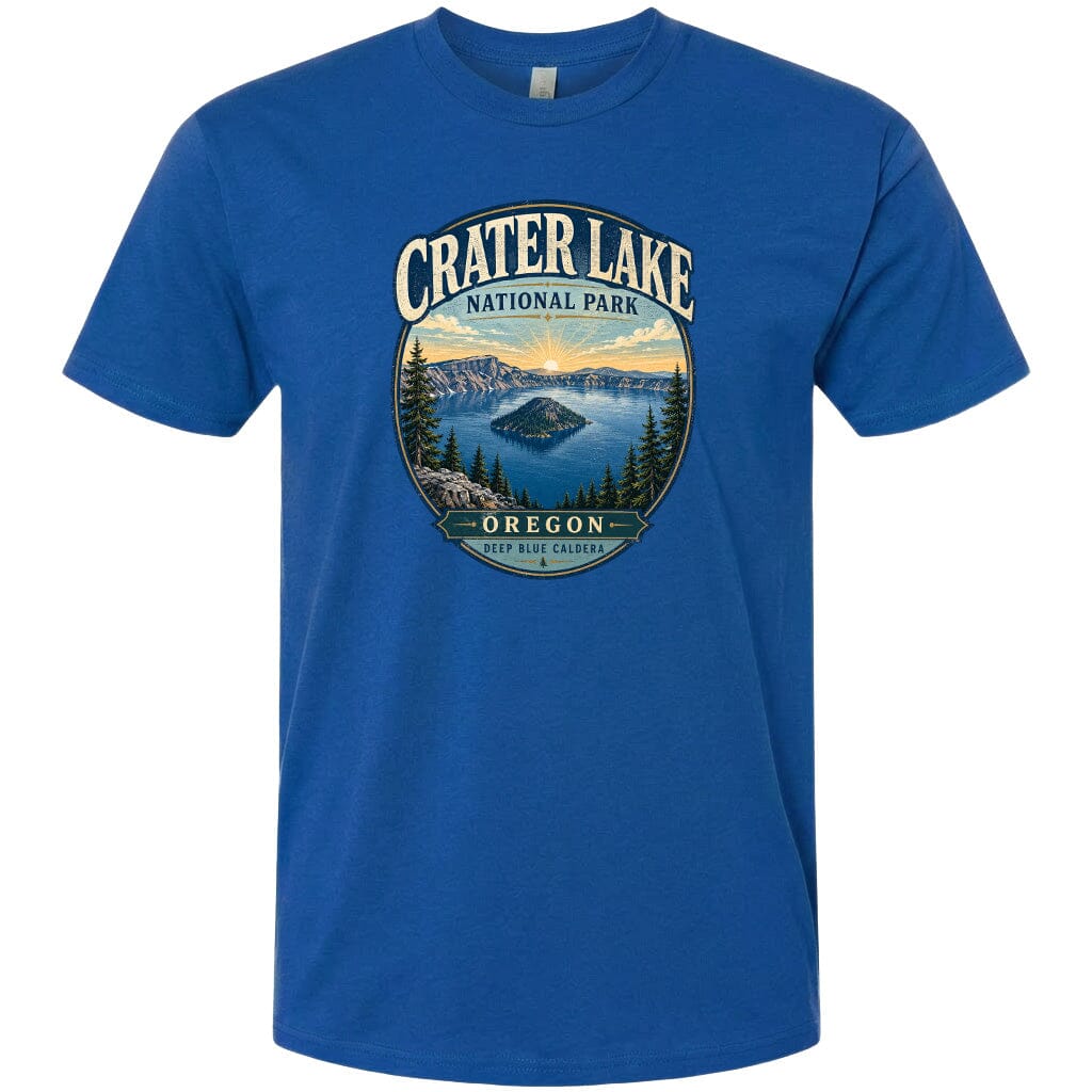 A blue t-shirt with a graphic design depicting Crater Lake National Park in Oregon, featuring a scenic landscape with a lake, mountains, and pine trees.