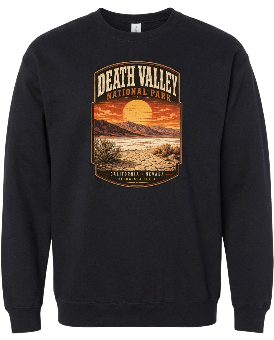 A black sweatshirt with a graphic design depicting a desert landscape with mountains, a sunset, and a desert plant.