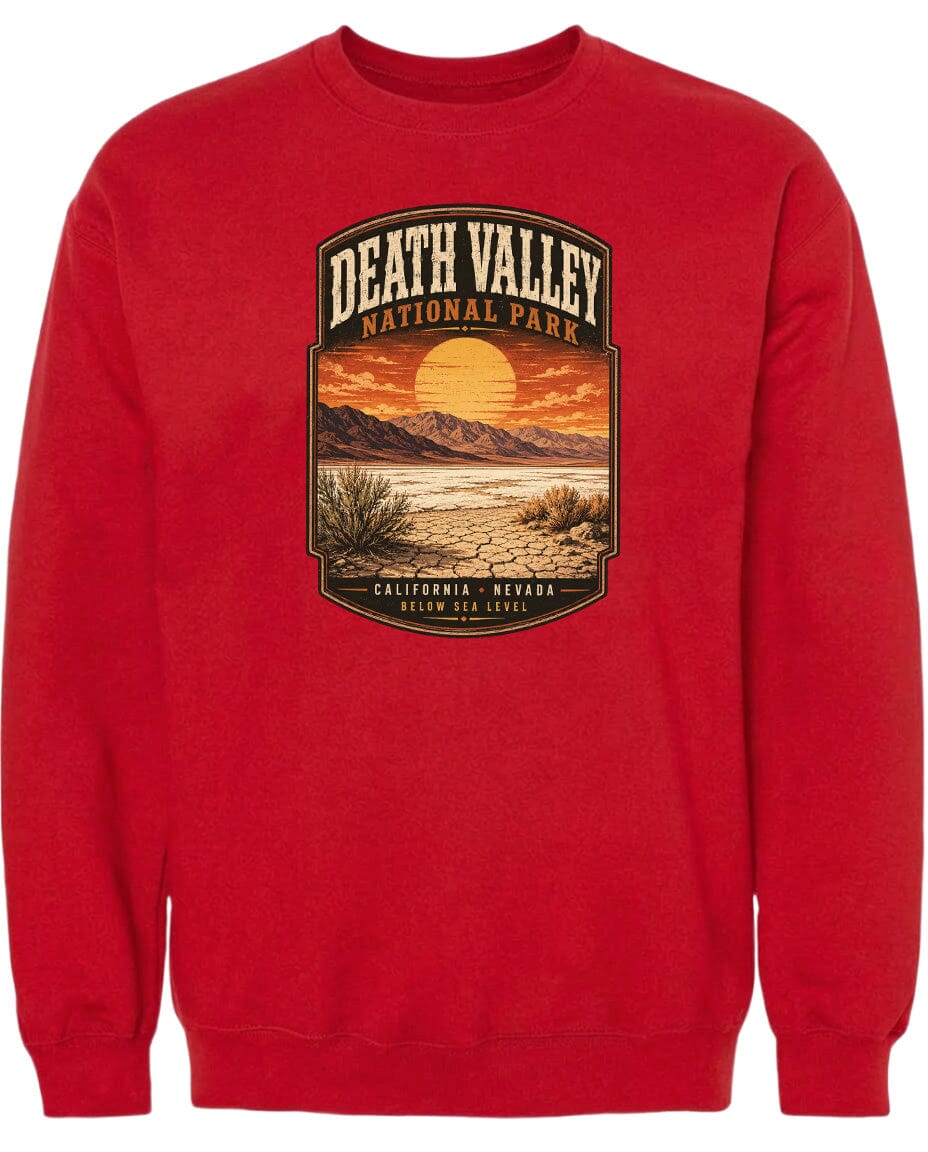 A red sweatshirt with a graphic design depicting a desert landscape with mountains, a sunset, and a desert plant.