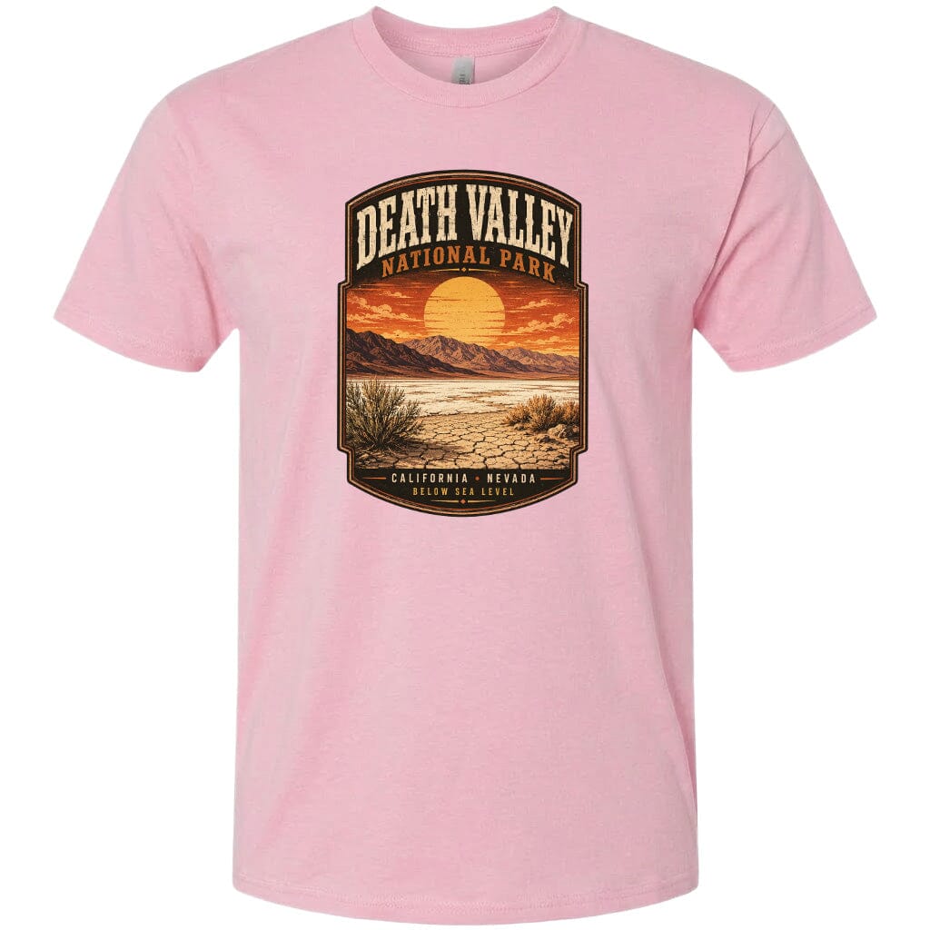 A pink t-shirt with a graphic design depicting a desert landscape with mountains, a sunset, and a label that reads "DEATH VALLEY NATIONAL PARK CALIFORNIA NEVADA BELOW SEA LEVEL".