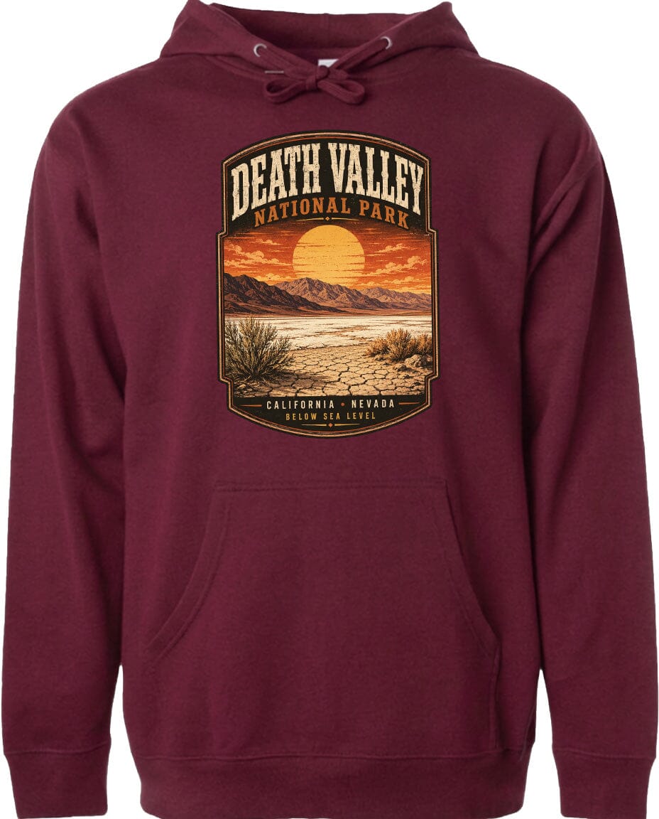 A burgundy-colored hoodie with a graphic design depicting a desert landscape with mountains, a sunset, and a cactus plant.