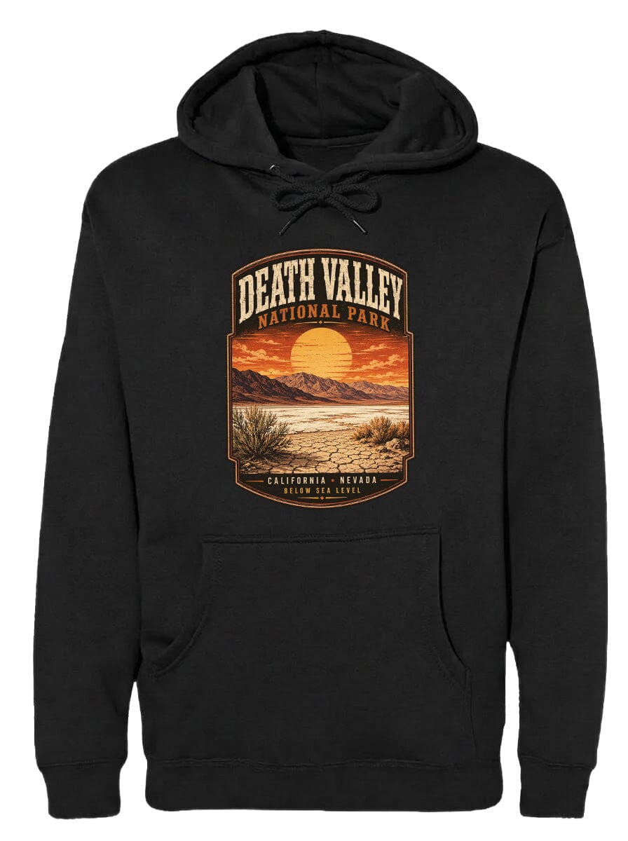 A black hoodie with a graphic design depicting a scenic landscape of Death Valley National Park, including mountains, a sunset, and desert vegetation.