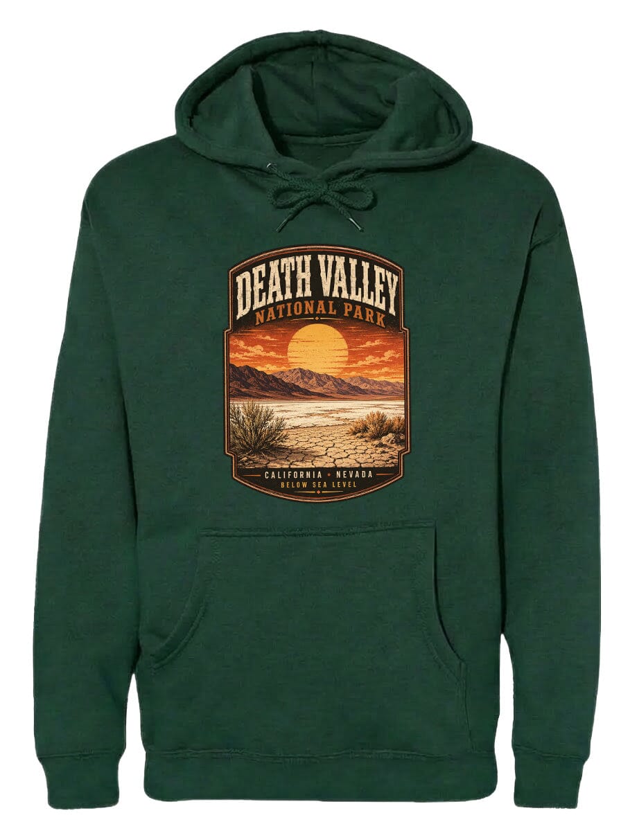 A green hoodie with a graphic design depicting Death Valley National Park, including a sunset over the mountains and desert landscape.