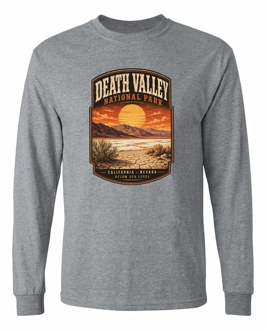 A gray long-sleeved t-shirt with a graphic design depicting a desert landscape with mountains, a sunset, and a desert plant.