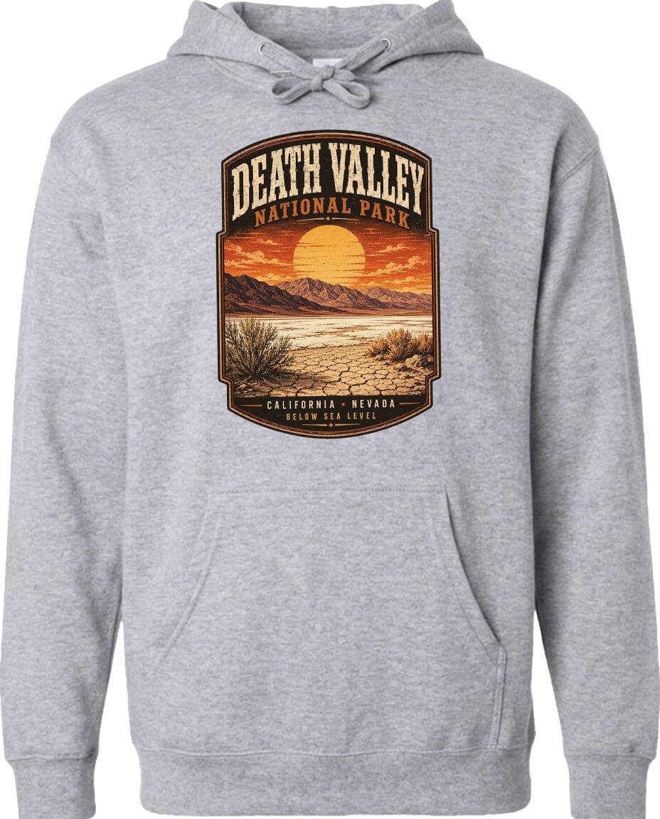 A gray hoodie with a graphic design depicting Death Valley National Park, including a sunset, mountains, and desert landscape.