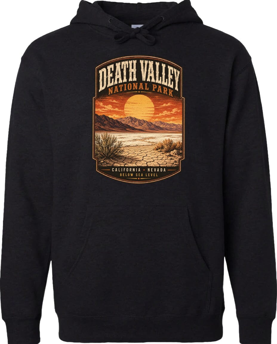 A black hoodie with a graphic design depicting a desert landscape with mountains, a sunset, and a desert plant.