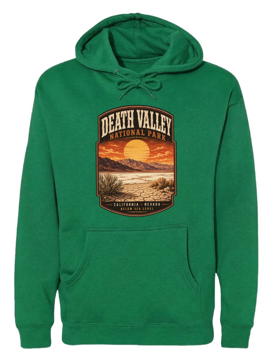 A green hoodie with a graphic design depicting Death Valley National Park, including a sunset over the mountains and desert landscape.