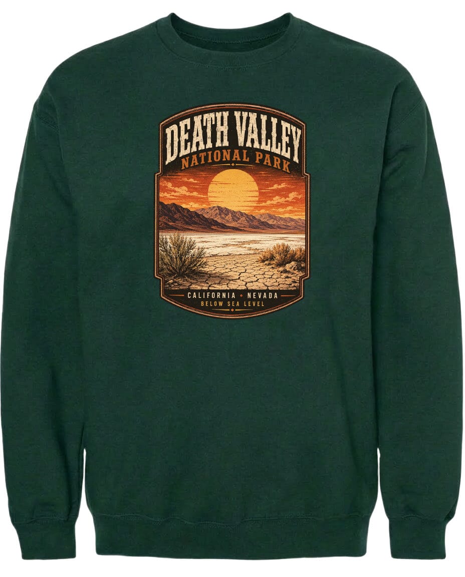 A green sweatshirt with a graphic design depicting Death Valley National Park, including a sunset, mountains, and desert landscape.