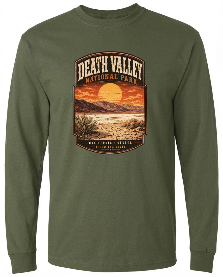A long-sleeved green t-shirt with a graphic design depicting a desert landscape with mountains, a sunset, and a label that reads "DEATH VALLEY NATIONAL PARK CALIFORNIA NEVADA BELOW SEA LEVEL".