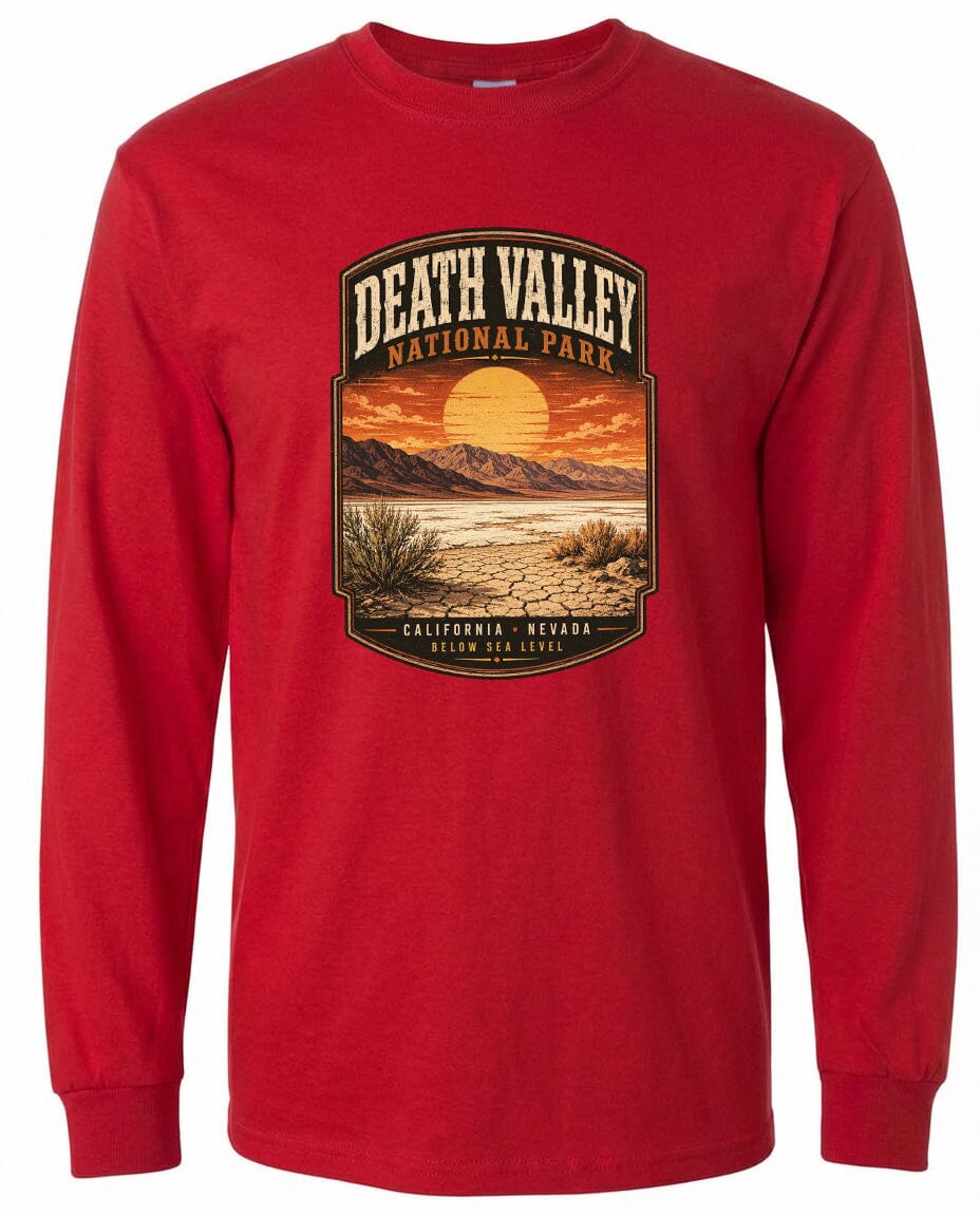 A red long-sleeved t-shirt with a graphic design depicting a desert landscape with mountains, a sunset, and a desert plant.