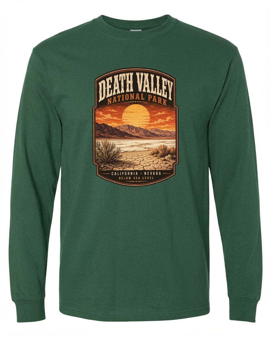 A green long-sleeved t-shirt with a graphic design depicting a desert landscape with mountains, a sunset, and a cactus plant.