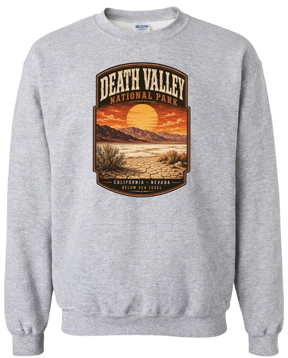 A gray sweatshirt with a graphic design depicting a desert landscape with mountains, a sunset, and a desert-like terrain.
