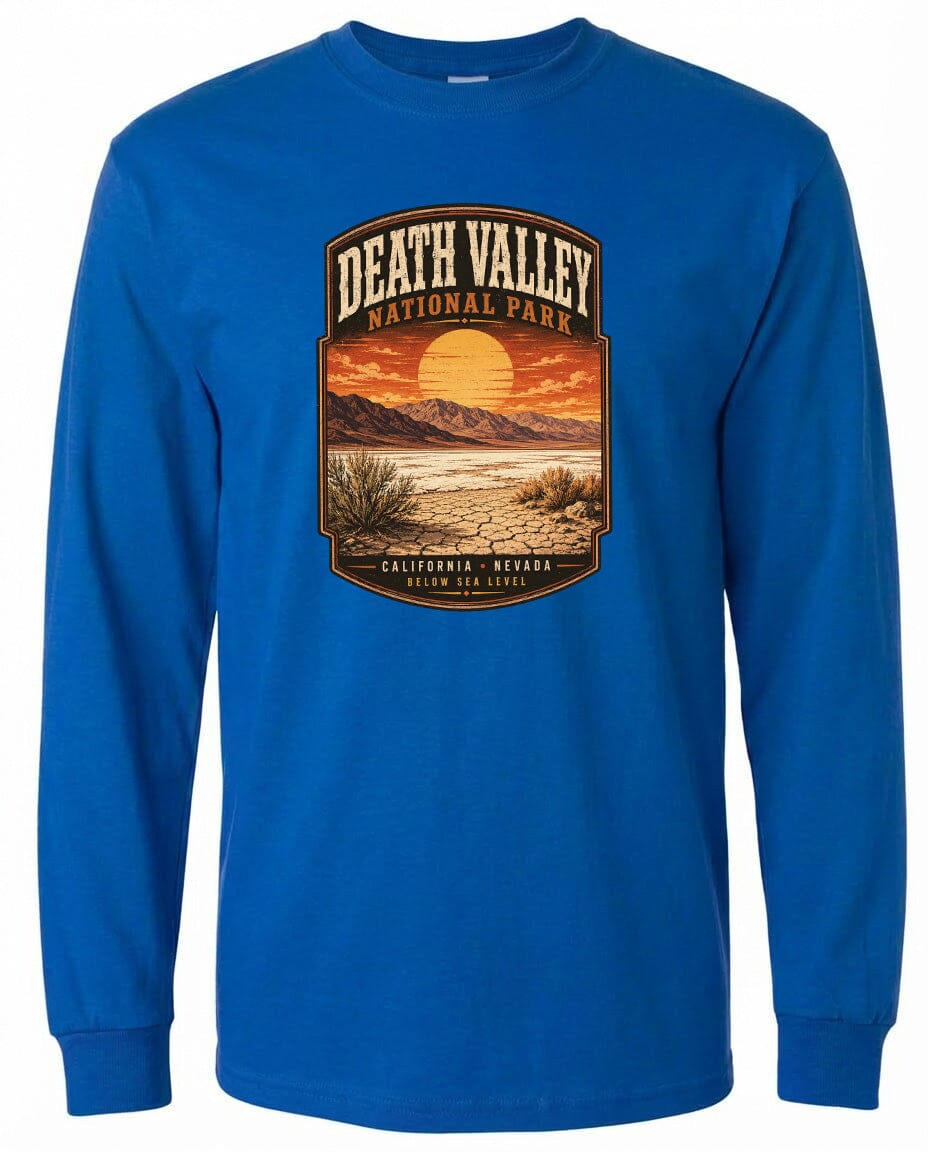 A blue long-sleeved t-shirt with a graphic design depicting Death Valley National Park, including a sunset, mountains, and desert landscape.