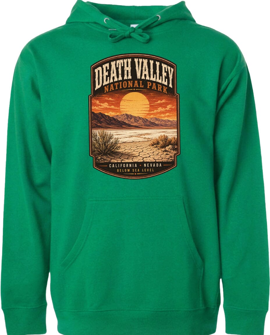 A green hoodie with a graphic design depicting Death Valley National Park, including a desert landscape and a sunset.