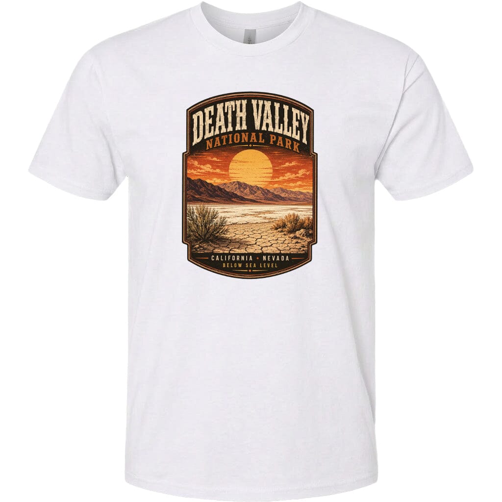 A white t-shirt with a graphic design depicting a desert landscape with mountains, a sunset, and a desert plant.