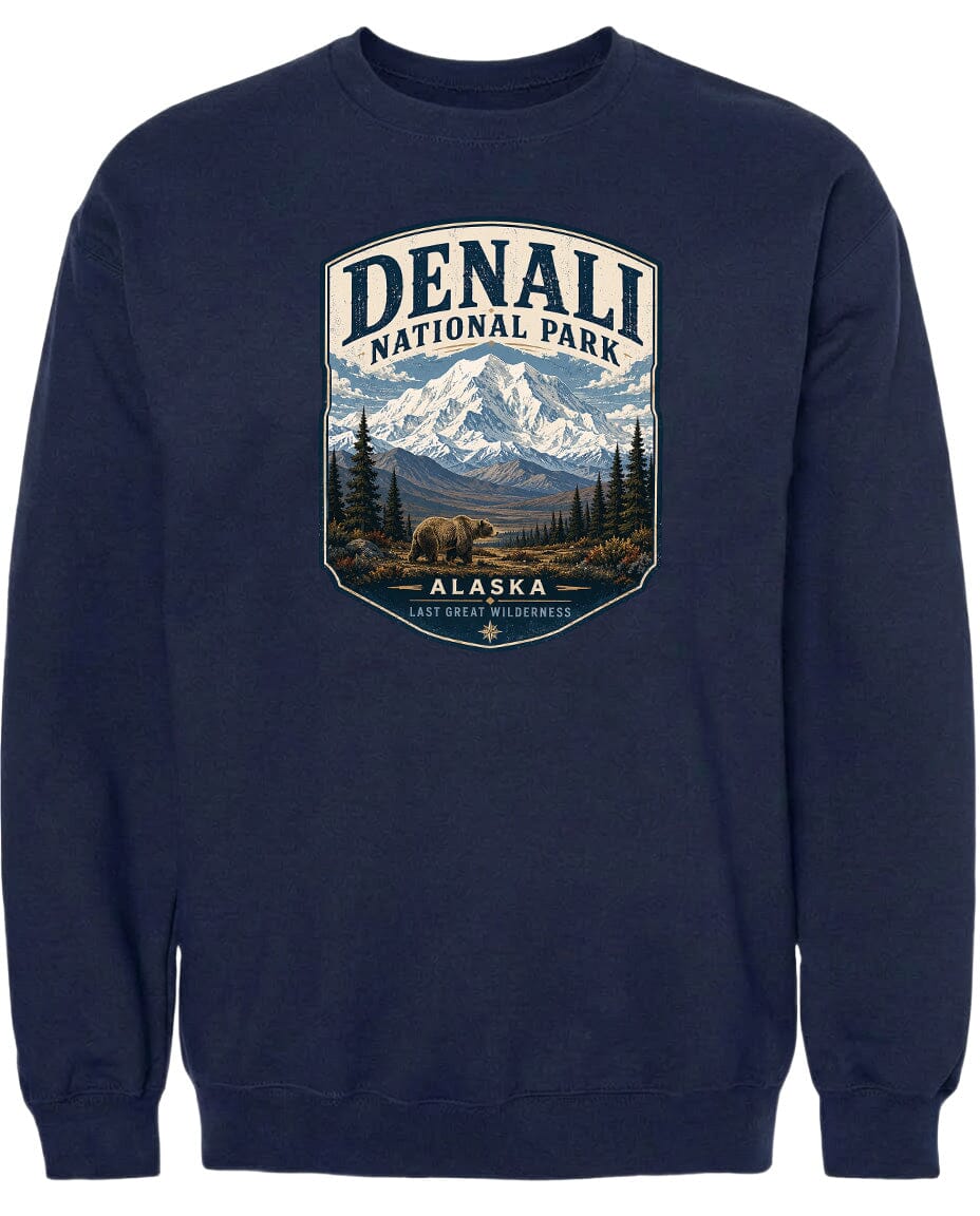 A navy blue sweatshirt with a graphic design depicting a bear in the foreground, surrounded by a mountainous landscape with pine trees and snow-capped peaks.
